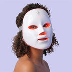 Woman wearing GlowUp LED red light therapy mask, front view
